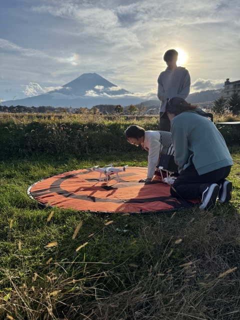 富士山を背景に、ドローン操作を楽しむご家族の姿 富士山を背景に、ドローン操作を楽しむご家族の姿